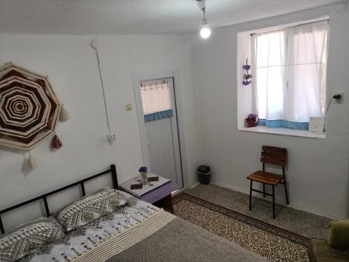 - une chambre avec un lit, une fenêtre et une chaise dans l'établissement Portakal Çiçeği, à Sefaçamlık