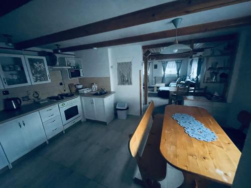 a kitchen with a wooden table and a dining room at Penzion U Rodinky in Bělá pod Pradědem