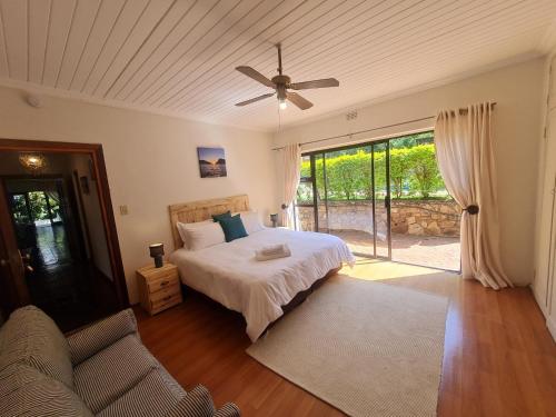 a bedroom with a bed and a ceiling fan at 60 on Monica, 6 Bedroom Lesedi Lodge, Hartbeespoort in Hartbeespoort