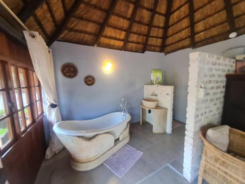 a bathroom with a tub and a toilet in a room at 60 on Monica, 6 Bedroom Lesedi Lodge, Hartbeespoort in Hartbeespoort
