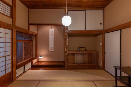 uma sala vazia com uma mesa e um candeeiro em 葉山 - Nowhere but Hayama em Hayama