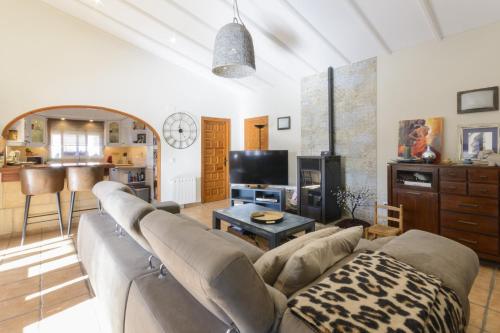 salon z kanapą i telewizorem w obiekcie Casa Lea w mieście Alcalalí
