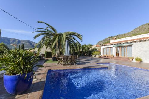 una piscina con sedie e una casa con montagne di Casa Lea ad Alcalalí