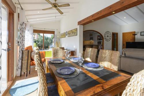 uma sala de jantar com mesa e cadeiras de madeira em Casa Lea em Alcalalí