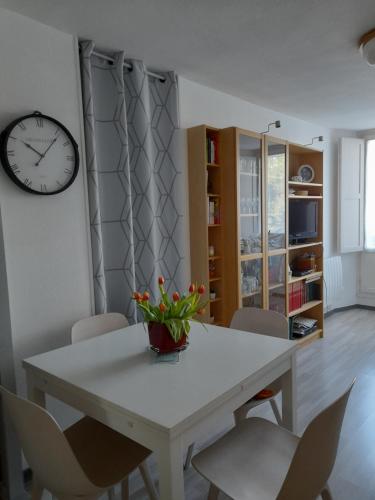 une table à manger avec des chaises et une horloge murale dans l'établissement T2bis, HYPER CENTRE FACE LES THERMES, à Luchon