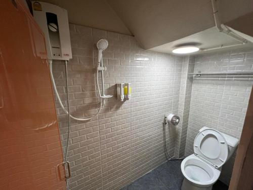 a bathroom with a shower and a toilet at Achcha Family Hotel in Bangkok