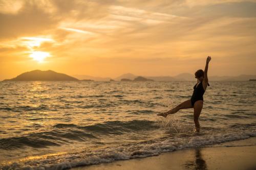 een vrouw springt in het water op het strand bij Sunset Beach Club Aqua Lettings in Fethiye