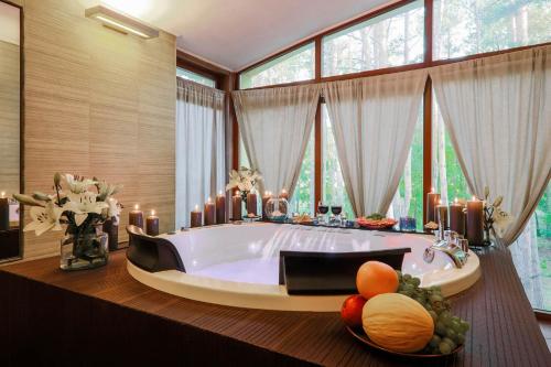 a large bathroom with a tub with candles and fruit in it at Hotel Magellan in Bronisławów