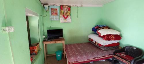 Habitación pequeña con cama pequeña y escritorio. en Rashi Home Stay Khati, en Bāgeshwar
