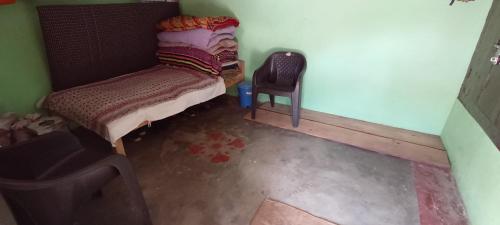 Habitación pequeña con cama y silla en Rashi Home Stay Khati, en Bāgeshwar