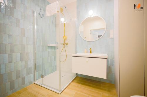 W łazience znajduje się prysznic, umywalka i lustro. w obiekcie Polanki AQUA Premium Class by MS Pro Apartamenty w Kołobrzegu