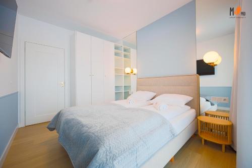 1 dormitorio blanco con 1 cama con 2 almohadas en Polanki AQUA Premium Class by MS Pro Apartamenty en Kołobrzeg