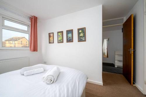 a bedroom with a white bed with two towels on it at GuestReady - Tranquil Retreat near the Royal Docks in London