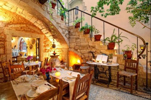 a restaurant with tables and chairs and a staircase at Veneto Boutique Hotel in Rethymno Town