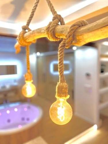 a group of lights hanging from a rope in a bathroom at Le Zen - Sauna - Balnéo - Sparoom Sarreguemines in Sarreguemines