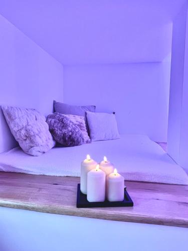 two candles sitting on a bed in a room at Le Zen - Sauna - Balnéo - Sparoom Sarreguemines in Sarreguemines