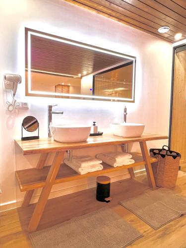 a bathroom with two sinks and a large mirror at Le Zen - Sauna - Balnéo - Sparoom Sarreguemines in Sarreguemines