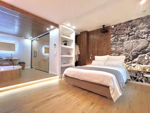 una camera con un grande letto e una vasca da bagno di Le Zen - Sauna - Balnéo - Sparoom Sarreguemines a Sarreguemines