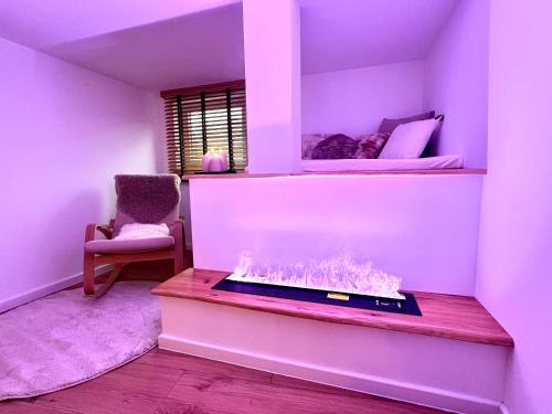a room with a fireplace with a bed in the background at Le Zen - Sauna - Balnéo - Sparoom Sarreguemines in Sarreguemines