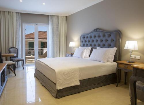 una camera con un grande letto e un balcone di VK Luxury Suites Nidri Lefkada - Adults Only a Nydri