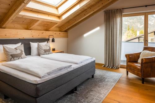 sypialnia z dużym łóżkiem i krzesłem w obiekcie Aurum Lodge w Garmisch Partenkirchen