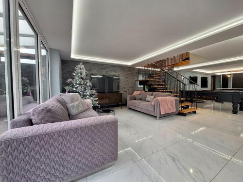a living room with two couches and a christmas tree at Moonsticks, Modern & Well Presented 5 Bed House in Spixworth