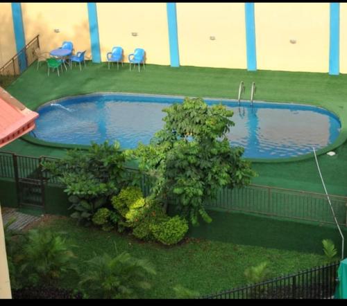 uma piscina num quintal com cadeiras e mesas em Ibadan Serviced Apartments em Ibadan