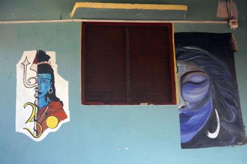 a window with a painting of a woman on a wall at Clan Boho in Rishīkesh