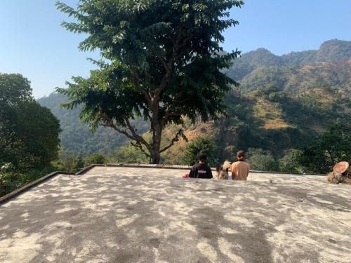 two people sitting on the top of a mountain at Clan Boho in Rishīkesh