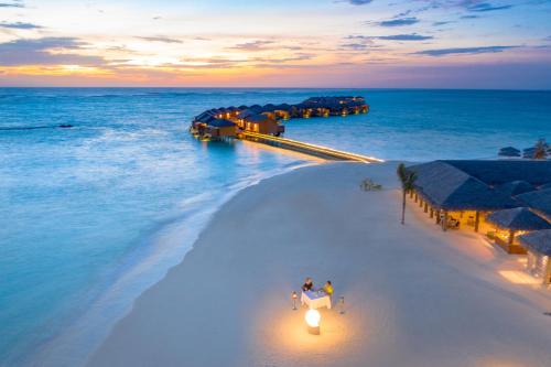 an aerial view of a beach at sunset at You & Me Maldives - Adults Only - Premium All-Inclusive in Raa Atoll