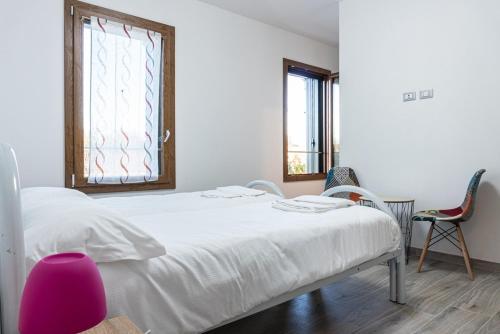 a bedroom with a white bed and two chairs at Villino Verde in Mira