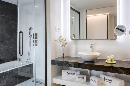 a bathroom with a sink and a glass shower at Barceló Imagine in Madrid