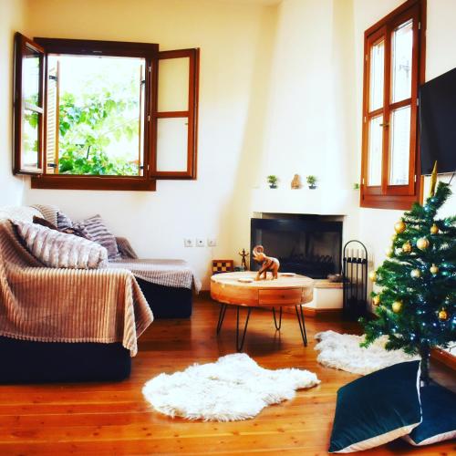 a living room with a christmas tree and a fireplace at Delfi's cozy maisonette in Delfoi