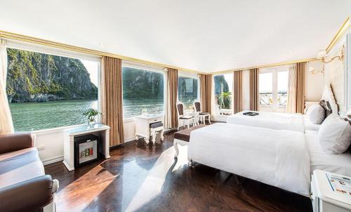 Aquamarine Premium Cruise في ها لونغ: غرفة نوم بسرير كبير ومدفأة