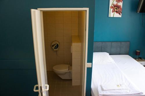 łazienka z toaletą i łóżko w pokoju w obiekcie Metropol Hostel Berlin w Berlinie