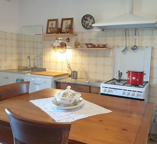 eine Küche mit einem Holztisch mit einem Teller darauf in der Unterkunft La casa dei nonni tra Crete Senesi e Val D'Orcia in San Giovanni dʼAsso