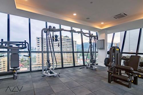 a gym with two tread machines in a room with windows at Urban Suites, Spectre Collection by Stellar ALV in Jelutong