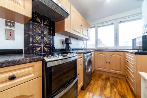 a kitchen with wooden cabinets and a dishwasher at Amazing 1 BR apartment, Barons Court in London