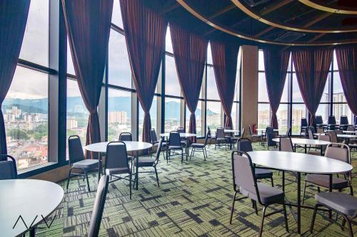 a dining room with tables and chairs and windows at Urban Suites, Spectre Collection by Stellar ALV in Jelutong