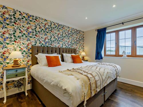 a bedroom with a large bed with floral wallpaper at 3 Bed in Westward Ho 89869 in Westward Ho