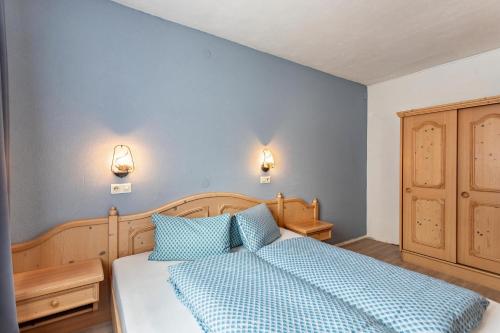 a bedroom with a bed with two blue pillows at Schwüwong - Apartment 02 in Kelchsau