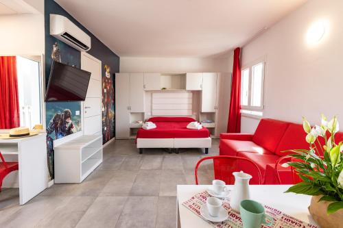 ミザーノ・アドリアーティコにあるRabbit Homeのリビングルーム(赤いソファ、ベッド付)