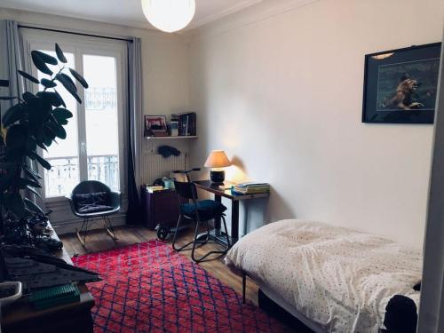 une chambre avec un lit, un bureau et une fenêtre dans l'établissement 3 bedrooms apartment, Parisian style, à Paris