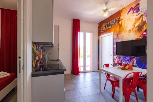 a kitchen with a table and red chairs in a room at Rabbit Home in Misano Adriatico