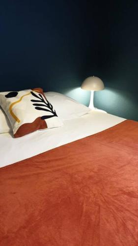 1 dormitorio con 1 cama con lámpara. en Blue**** Vue exceptionnelle sur le Rhône, en Tain-lʼHermitage