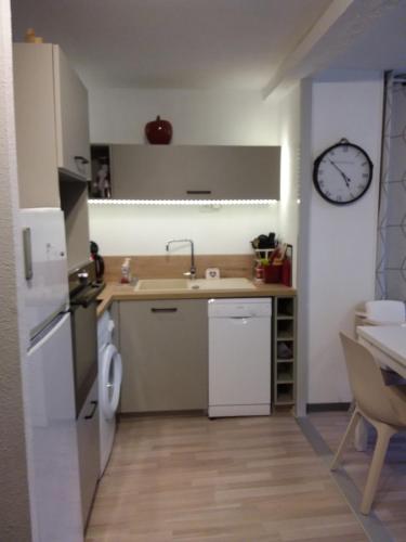 une petite cuisine avec un évier et une horloge murale dans l'établissement T2bis, HYPER CENTRE FACE LES THERMES, à Luchon