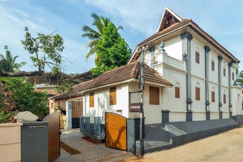 a white house with a gate in front of it at The Mundanad House in Trivandrum