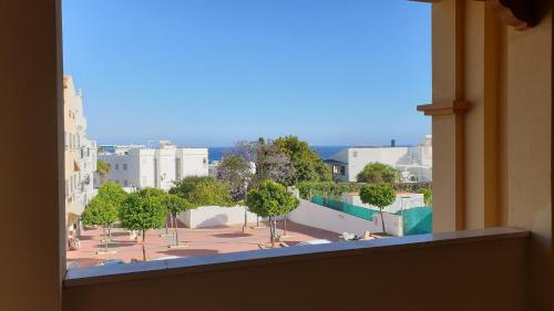 een raam van een gebouw met uitzicht op een binnenplaats bij Apartamento Milenio Nerja in Nerja