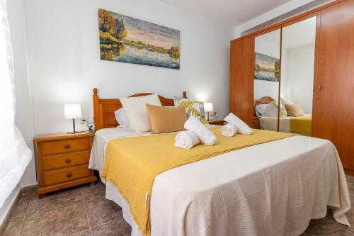 um quarto com uma cama grande e um cobertor amarelo em rentafive Nuevo AA conductos Parking em Santa Pola