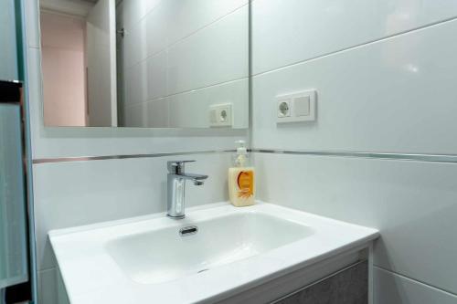 uma casa de banho com um lavatório e um espelho em rentafive Nuevo AA conductos Parking em Santa Pola